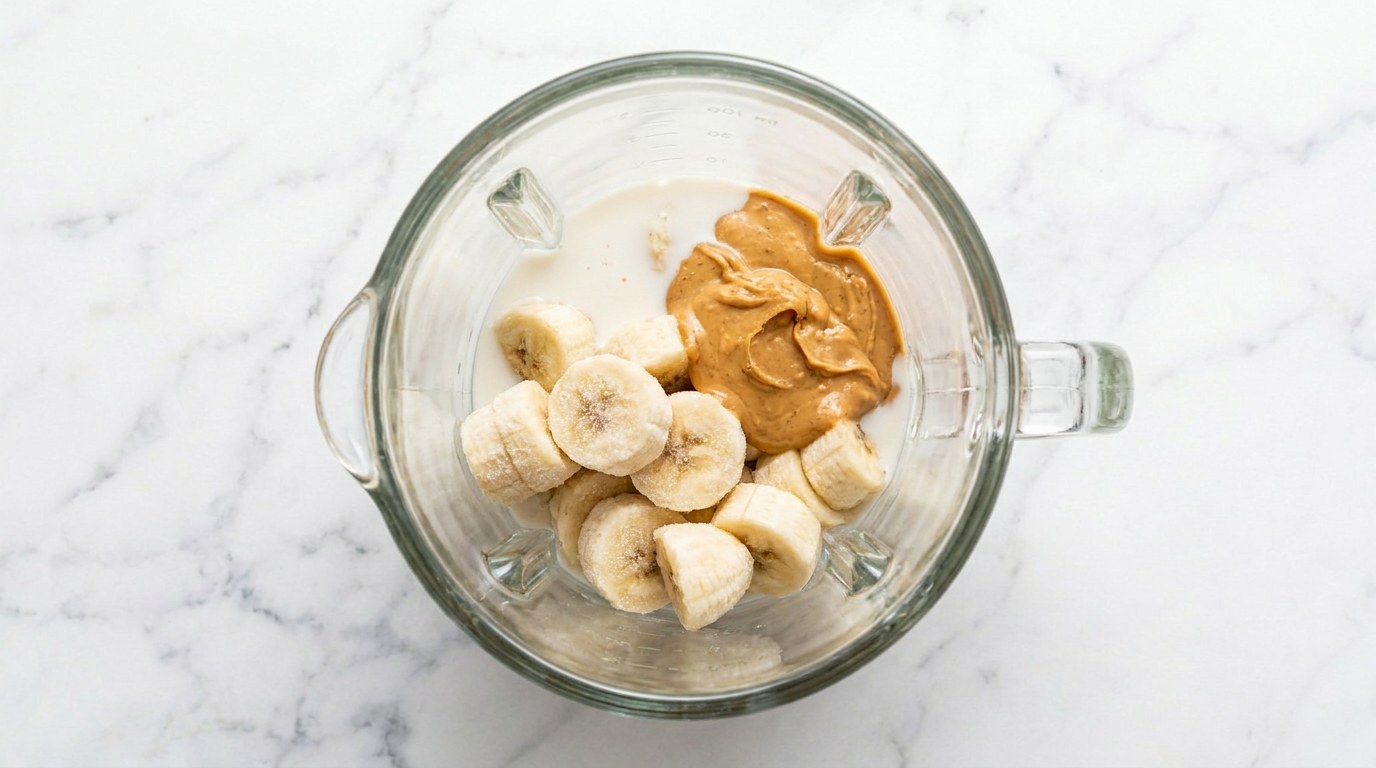 Stap 2: Doe de bevroren bananen met de pindakaas, melk en een snufje zout in de blender.
