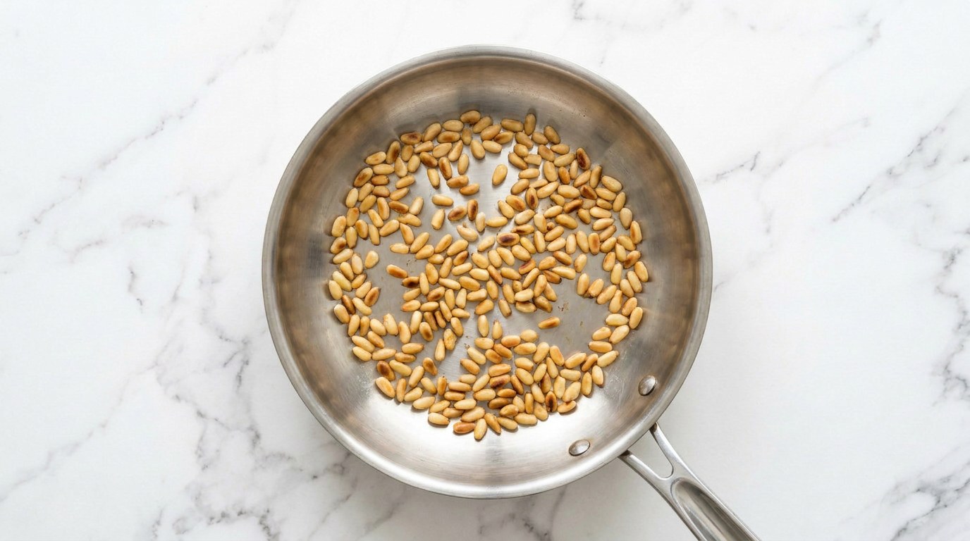 Stap 2: Rooster de pijnboompitten goudbruin in een droge koekenpan.