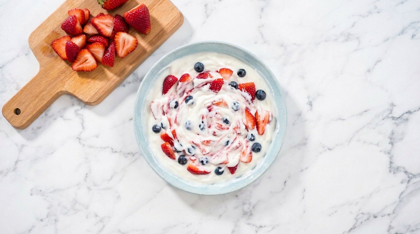 Stap 2: Snijd de aardbeien klein en meng ze met de blauwe bessen door de yoghurt.